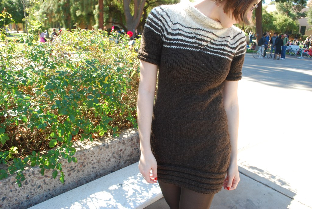 Girl wearing a knitted dress with a brown and white striped yoke