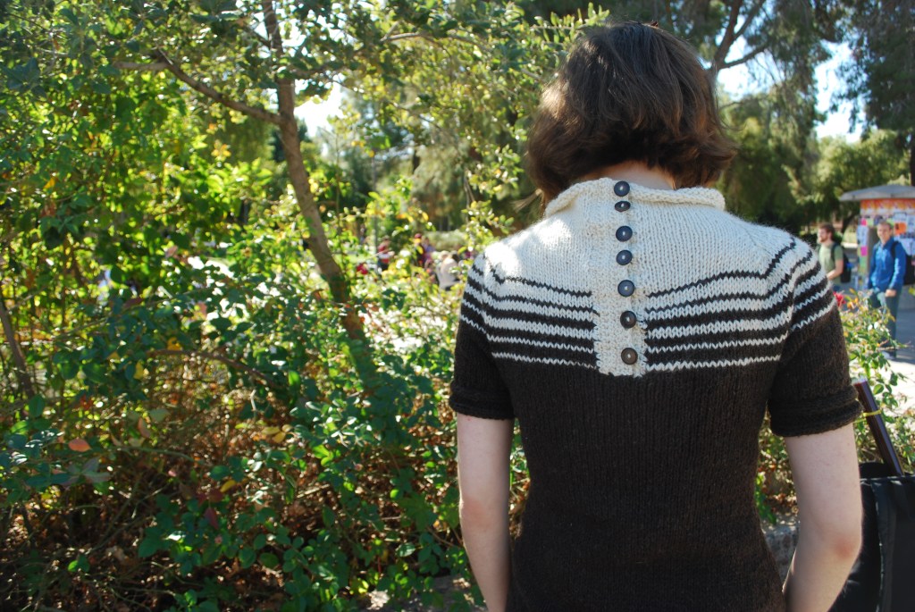 Girl wearing a knitted dress with a brown and white striped yoke