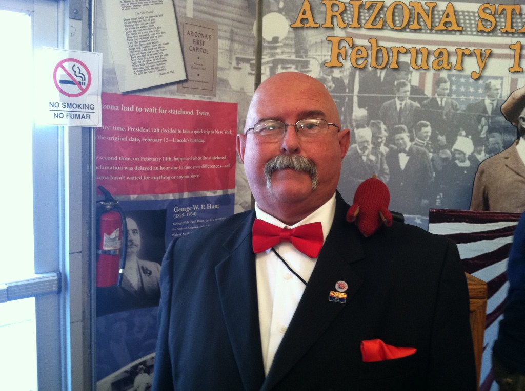 Mousie's Fifteen Seconds of Fame Knitted red mouse sitting on the shoulder of Governor George WP Hunt reenactor