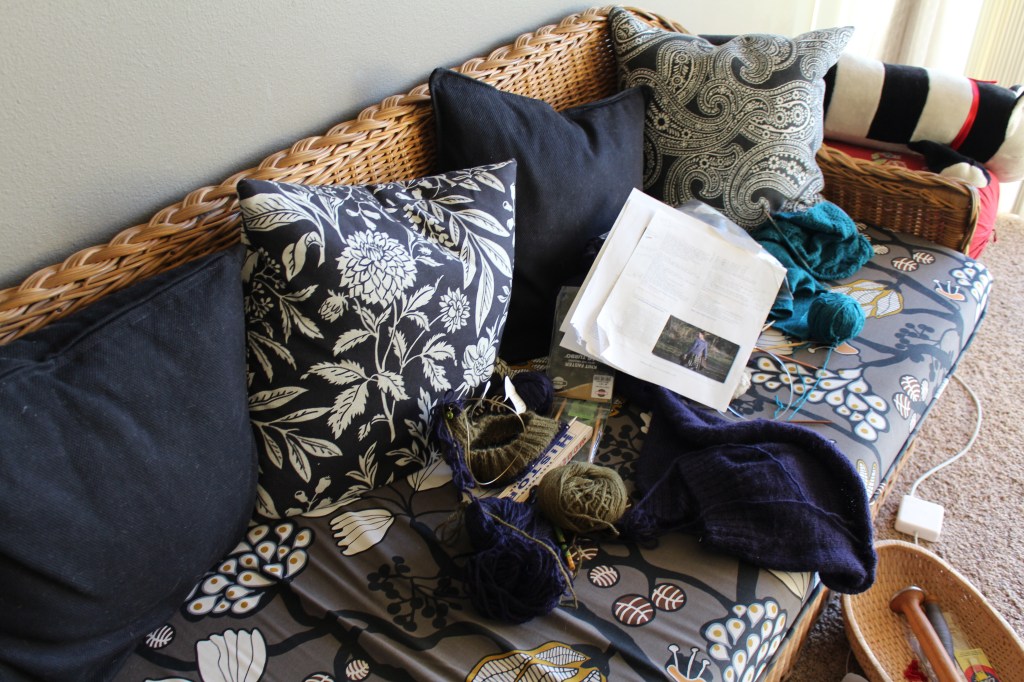 Wicker couch strewn with knitting