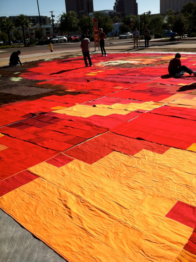 Volunteers adjusting blankets at art installation