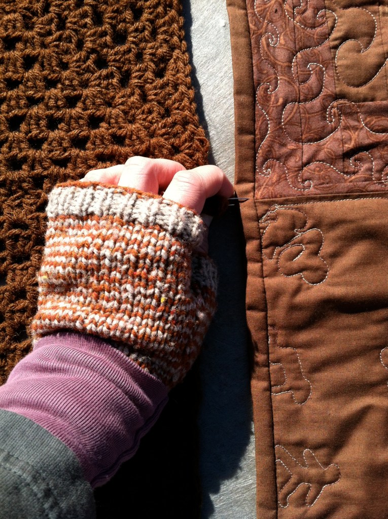 Mittened hand pinning blankets together