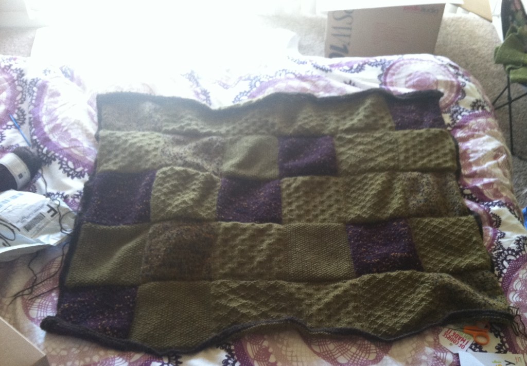 Knitted Patchwork Blanket spread out on a bed