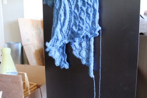 Two ends of a blue knitted stole