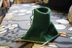 Dark green knitting on a sofa upholstered with Ikea fabric