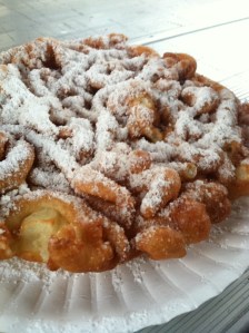 Funnel cake with powdered sugar on a paper plate