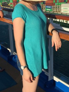 Front view of a woman wearing an open-backed sweater on a boat