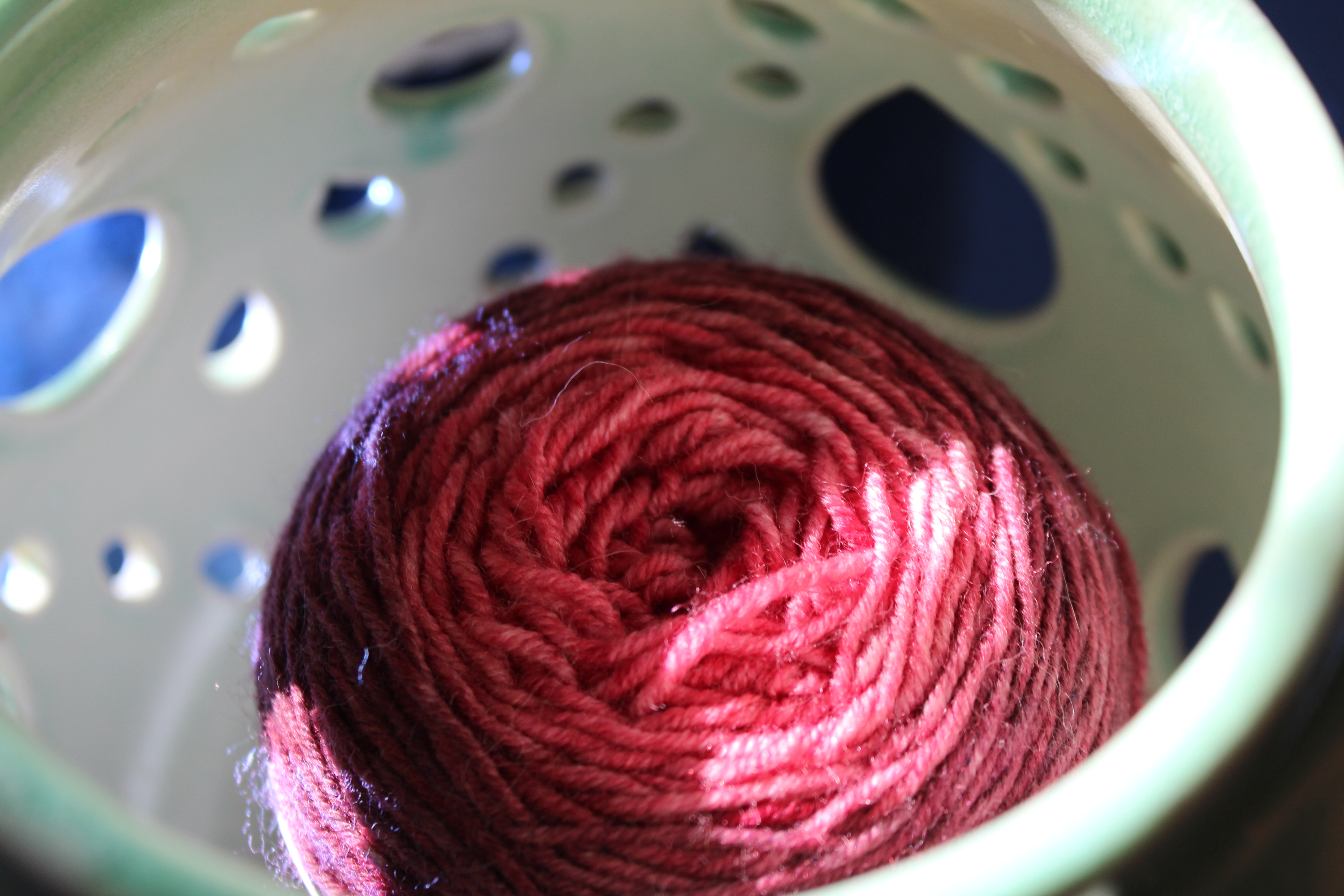 Pink and purple KnitCircus gradient yarn in a turquoise yarn bowl