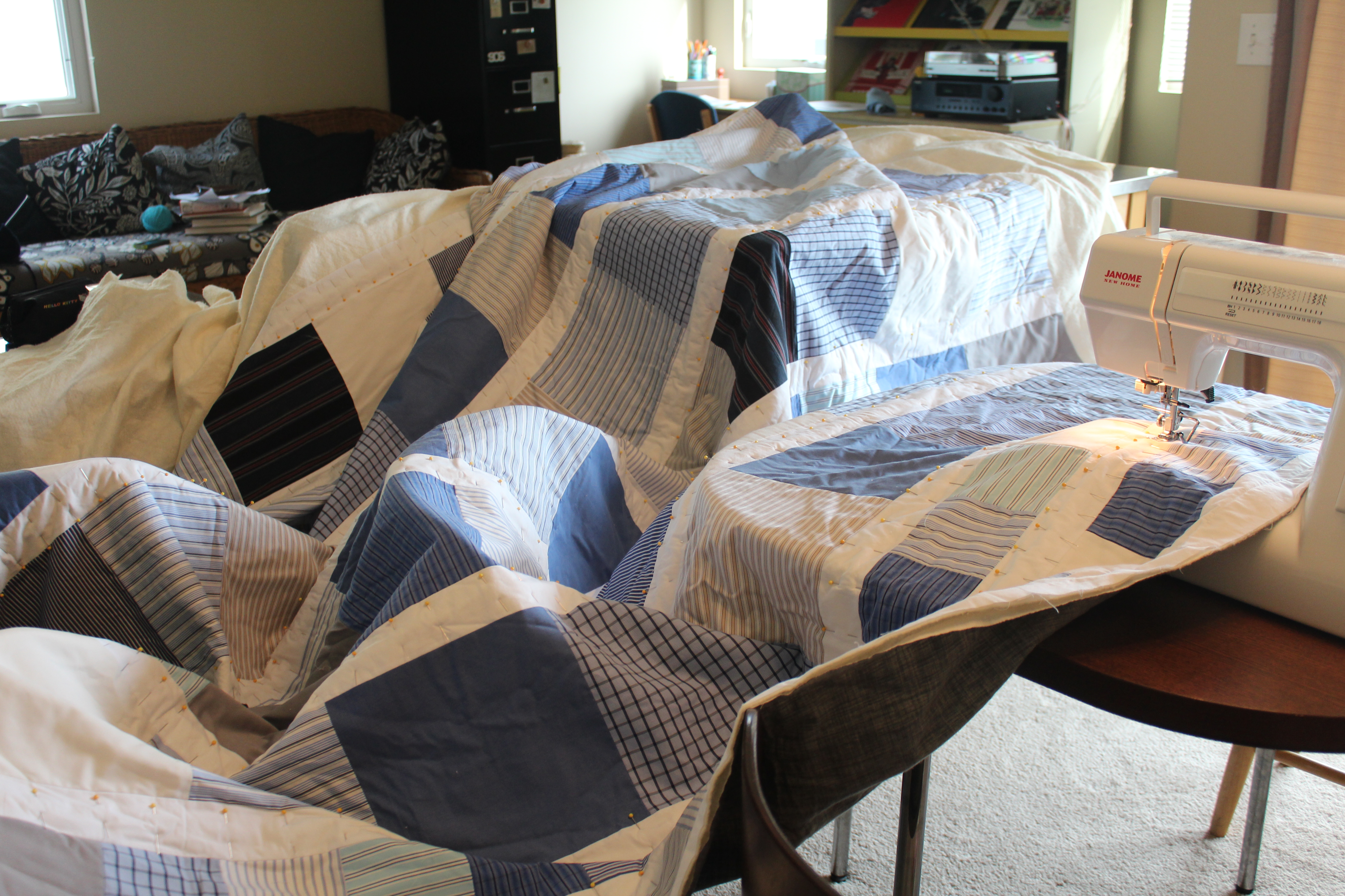 Large blue and white quilt spread out across tables