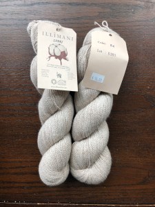 Illimani fingering weight cotton and alpaca blend yarn in pale fawn on a dark wood background
