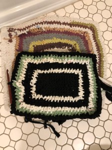 New bath mat crocheted out of recycled t-shirt fabric on top of old, ragged bath mat
