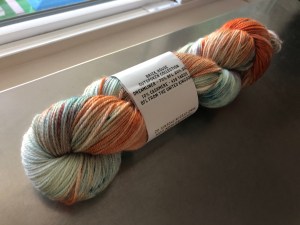 Turquoise and pale blue Less Traveled yarn on a dark background