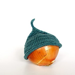 Image of a Little Sprout Hat by Heidi Gustad of Hands Occupied modeled on an onion with a smiley face drawn on, image copyright Heidi Gustad